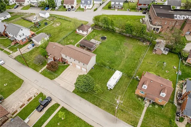 an aerial view of a house with garden space and street view