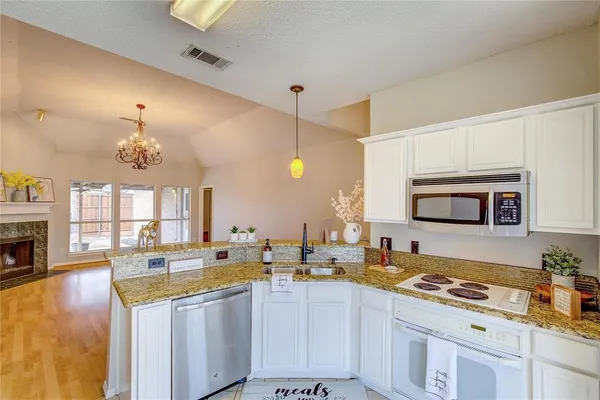 a large kitchen with stainless steel appliances a stove a sink dishwasher and cabinets with wooden floor