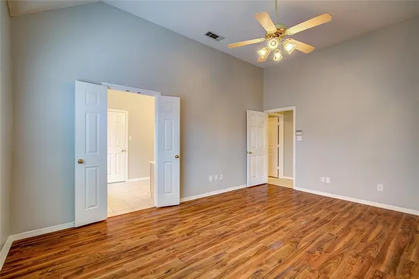 a view of an empty room with window and wooden floor