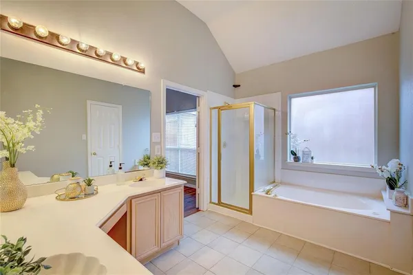 a bathroom with a tub sink and mirror