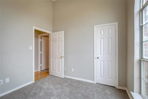 an empty room with windows and closet