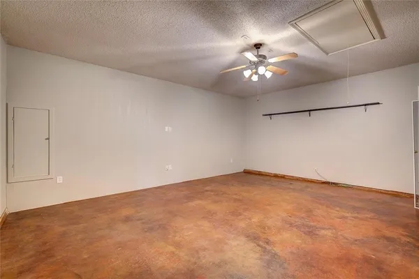 an empty room with ceiling fan and window