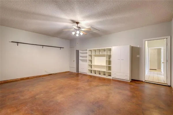 an empty room with fan and windows