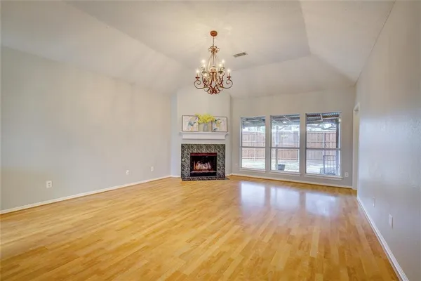 a view of an empty room with a window and a fireplace