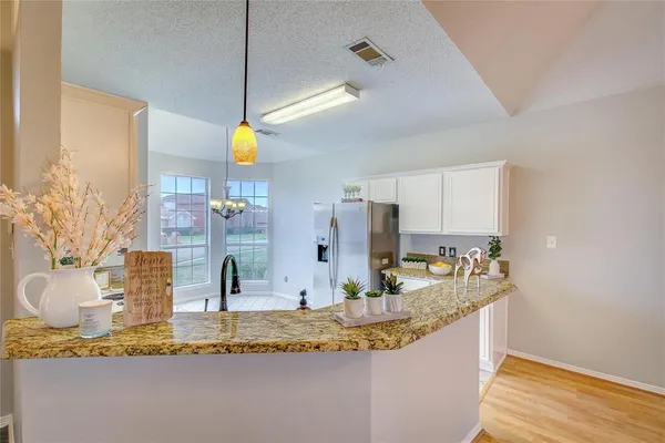 a kitchen with kitchen island granite countertop a sink and a counter top space