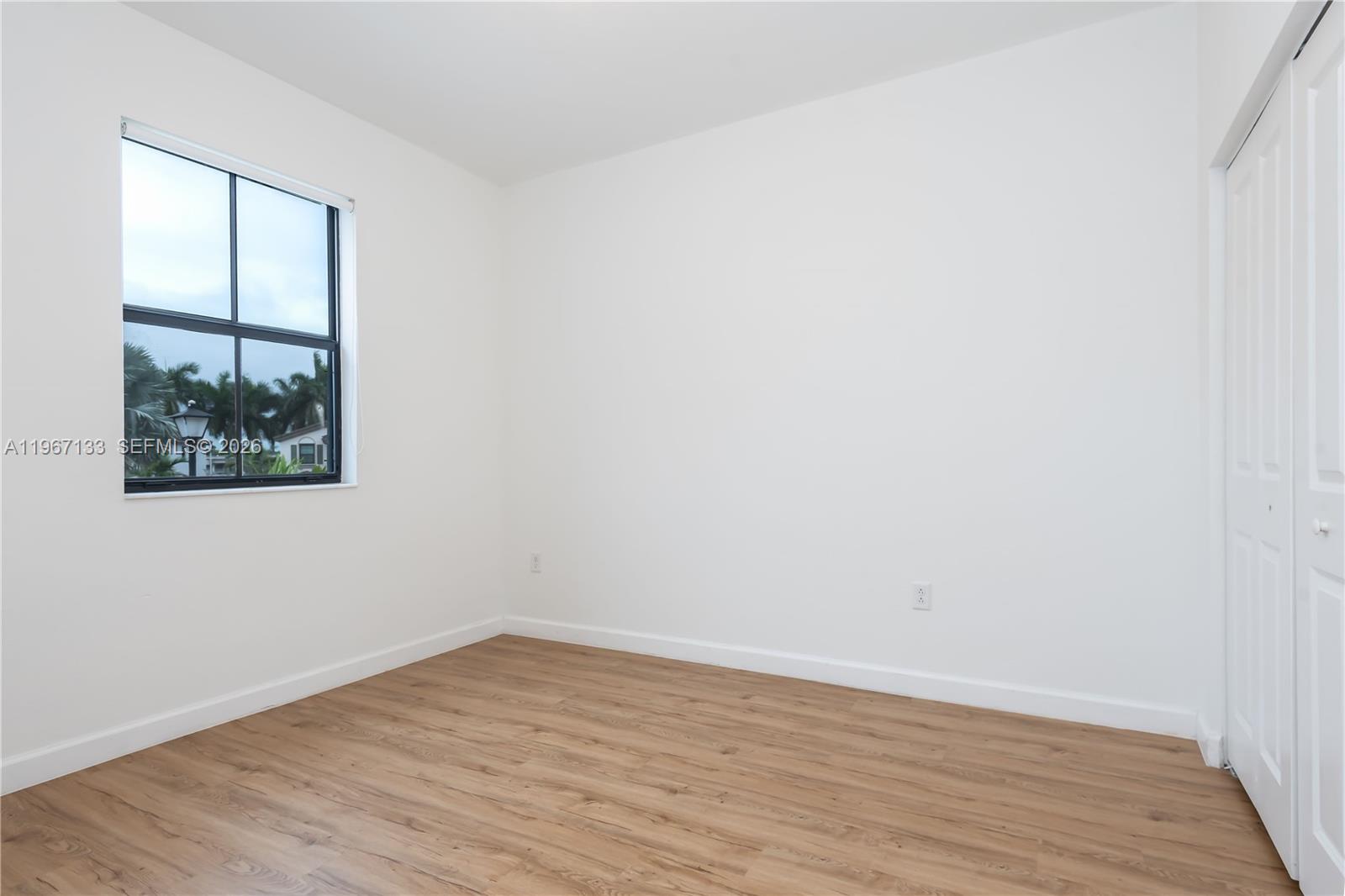 25128 Southwest 113th Place Homestead, FL 33032 - Photo 30 of 39 an empty room with wooden floor and window