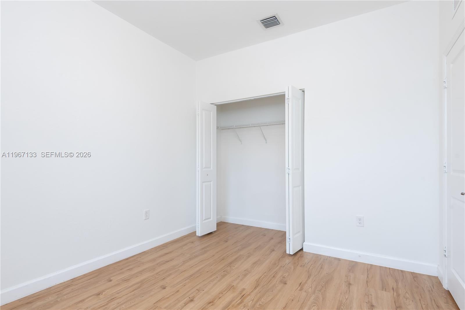 25128 Southwest 113th Place Homestead, FL 33032 - Photo 31 of 39 a view of an empty room with wooden floor and closet