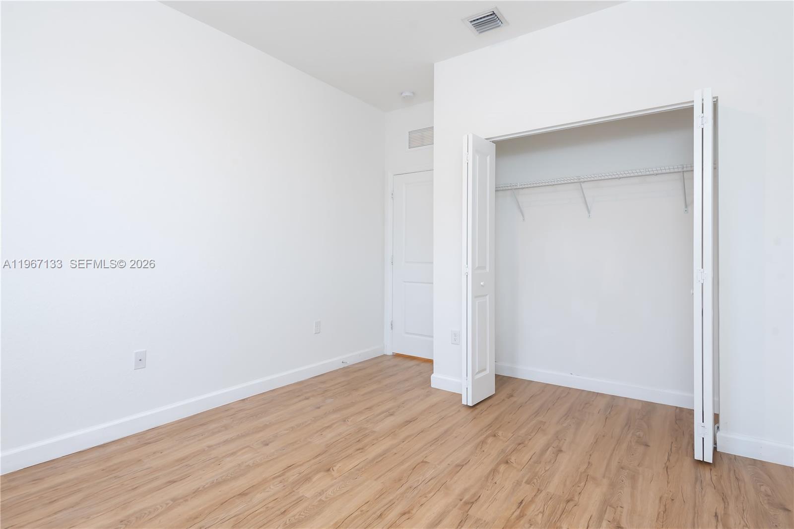 25128 Southwest 113th Place Homestead, FL 33032 - Photo 36 of 39 a view of an empty room with wooden floor and closet