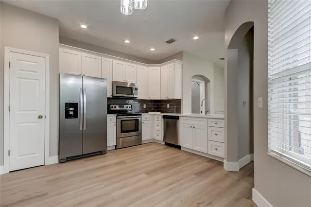 a kitchen with stainless steel appliances granite countertop a refrigerator and a stove top oven