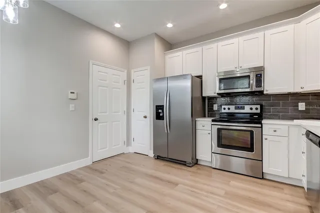 a kitchen with granite countertop a refrigerator and a stove top oven