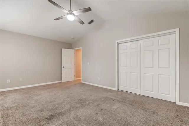 a view of an empty room and a ceiling fan window