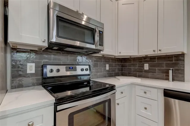 a kitchen with appliances a sink and cabinets