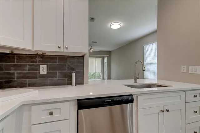 a kitchen with granite countertop white cabinets and black appliances