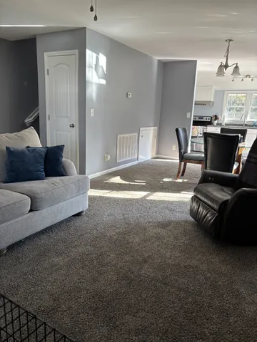 a living room with furniture and a chandelier