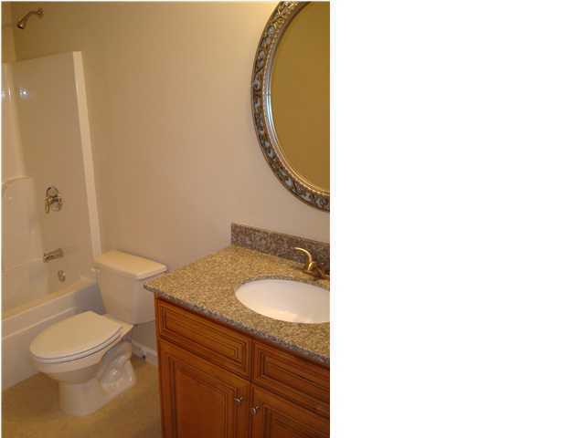 5237 Moore Loop Crestview, FL 32536 - Photo 17 of 17 a bathroom with a granite countertop toilet a sink and a mirror
