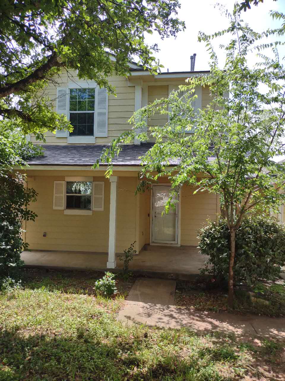11709 Briarcreek Loop Manor, TX 78653 - Photo 17 of 19 A classic facade with charming shutters and a welcoming front porch, enveloped by mature greenery.