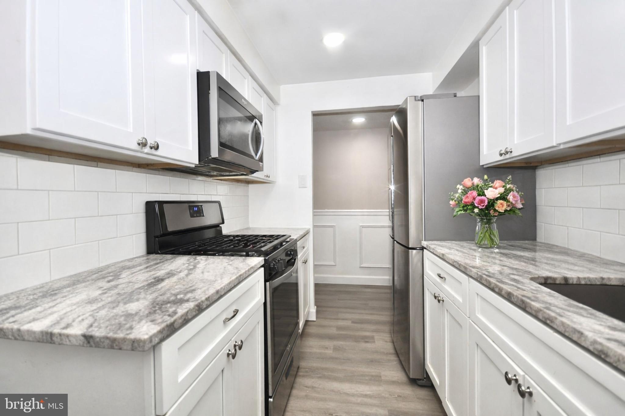 110 Byberry Road, Unit E2 Philadelphia, PA 19116 - Photo 2 of 10 a kitchen with stainless steel appliances granite countertop a sink stove and refrigerator