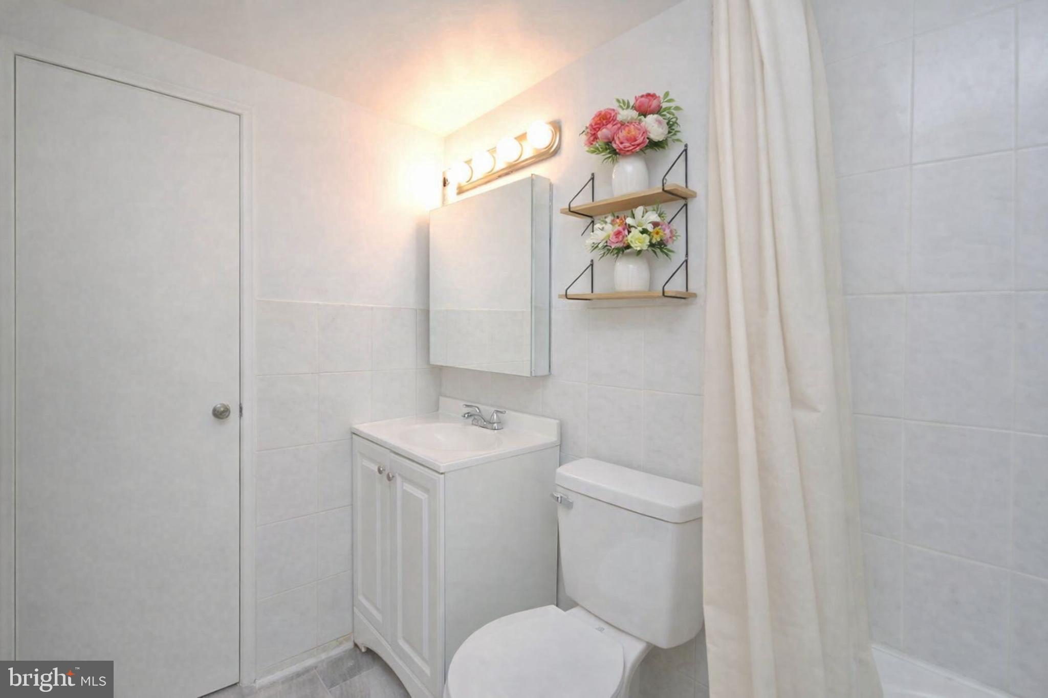 110 Byberry Road, Unit E2 Philadelphia, PA 19116 - Photo 5 of 10 a bathroom with a toilet a sink and mirror