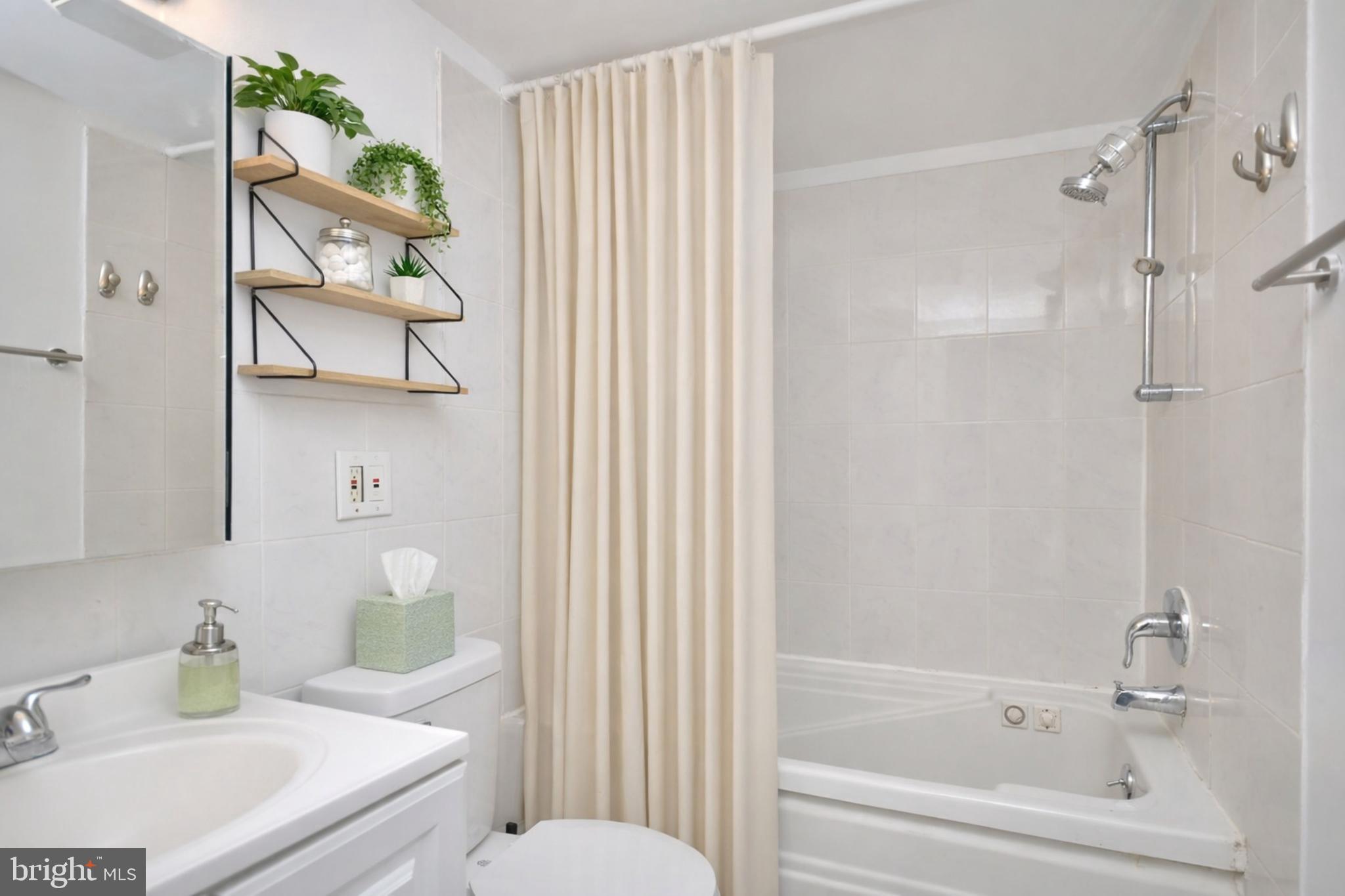 110 Byberry Road, Unit E2 Philadelphia, PA 19116 - Photo 6 of 10 a bathroom with a bathtub shower sink vanity and toilet