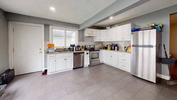 a kitchen with white cabinets and white appliances