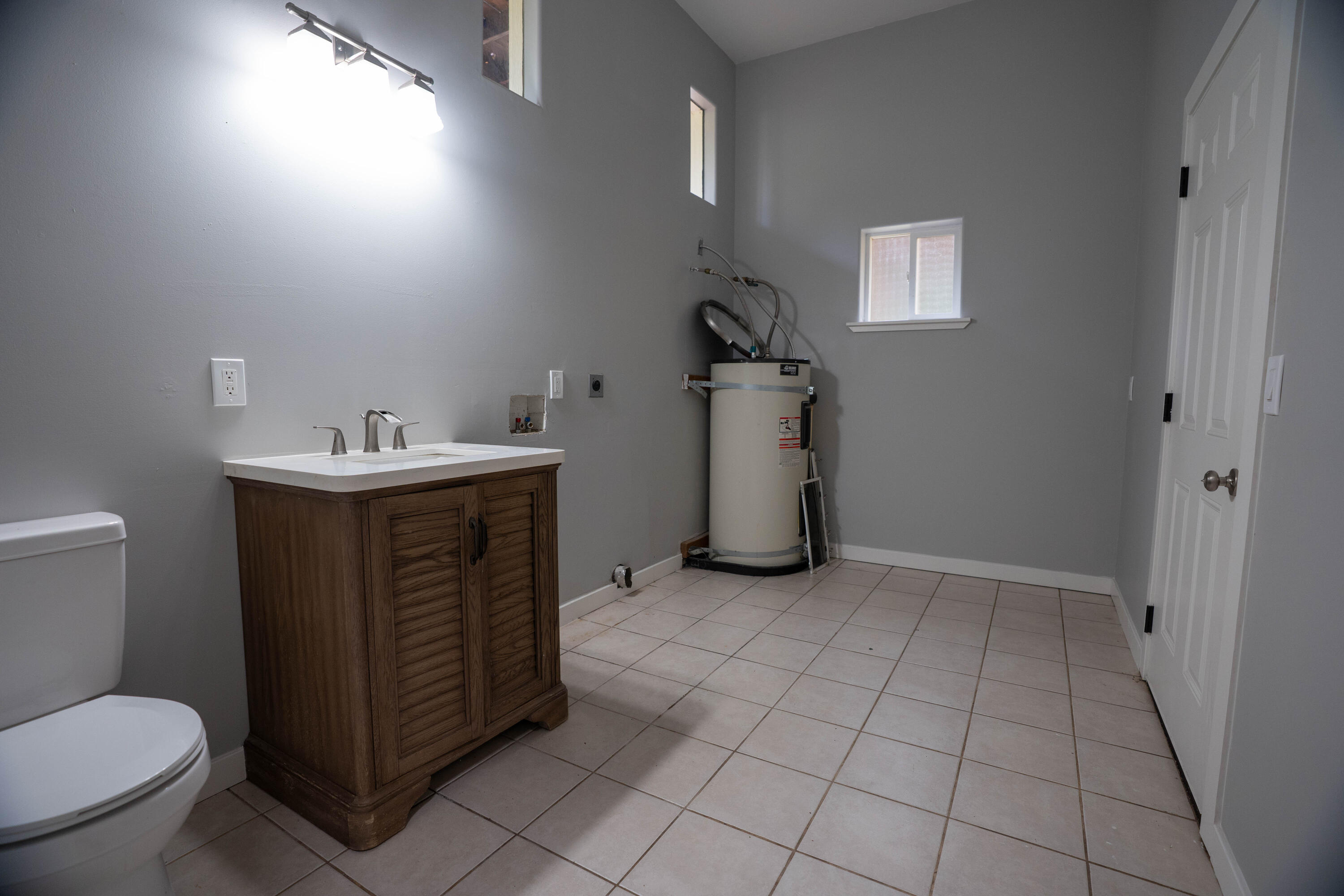 709 Pinewood Way Cave Junction, OR 97523 - Photo 22 of 24 a utility room with a sink a toilet and a mirror