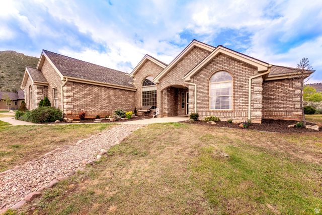 7343 North Sawtooth Cv Road Vernal, UT 84078 - Photo 50 of 64 Brick and stone facade residence featuring arched windows and a covered entry
