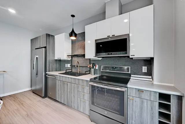 a kitchen with stainless steel appliances a dining table chairs and wooden floor