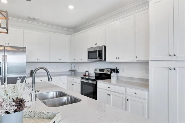 a very nice looking dining room with a large window cabinets and stainless steel appliances