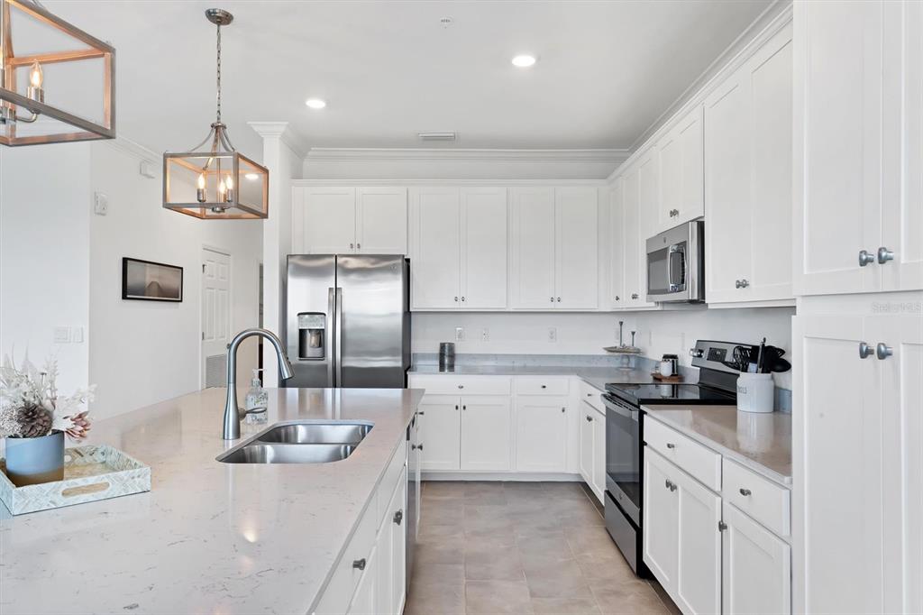 18114 Gawthrop Drive, Unit 405 Bradenton, FL 34211 - Photo 14 of 72 a kitchen with stainless steel appliances granite countertop a sink and dishwasher a refrigerator with white cabinets