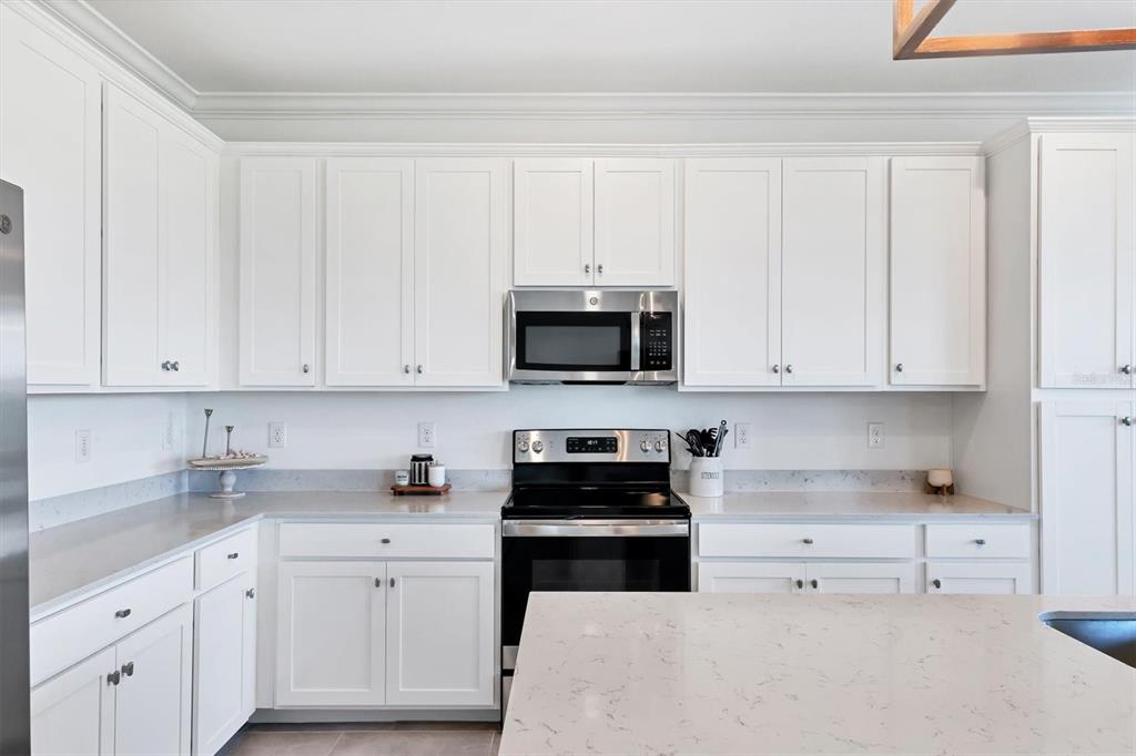 18114 Gawthrop Drive, Unit 405 Bradenton, FL 34211 - Photo 15 of 72 a kitchen with white cabinets and stainless steel appliances