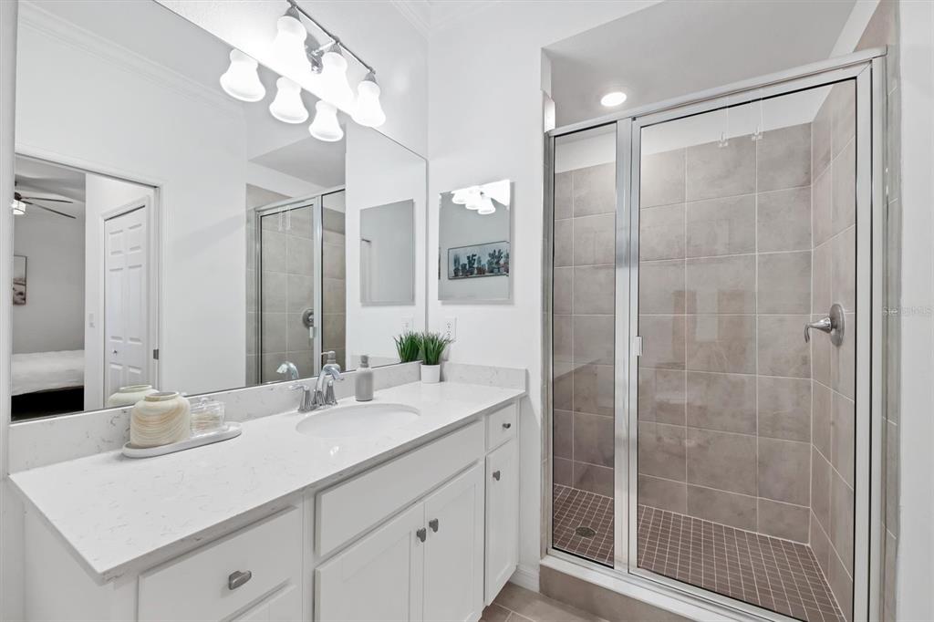 18114 Gawthrop Drive, Unit 405 Bradenton, FL 34211 - Photo 21 of 72 a bathroom with a shower sink vanity and mirror