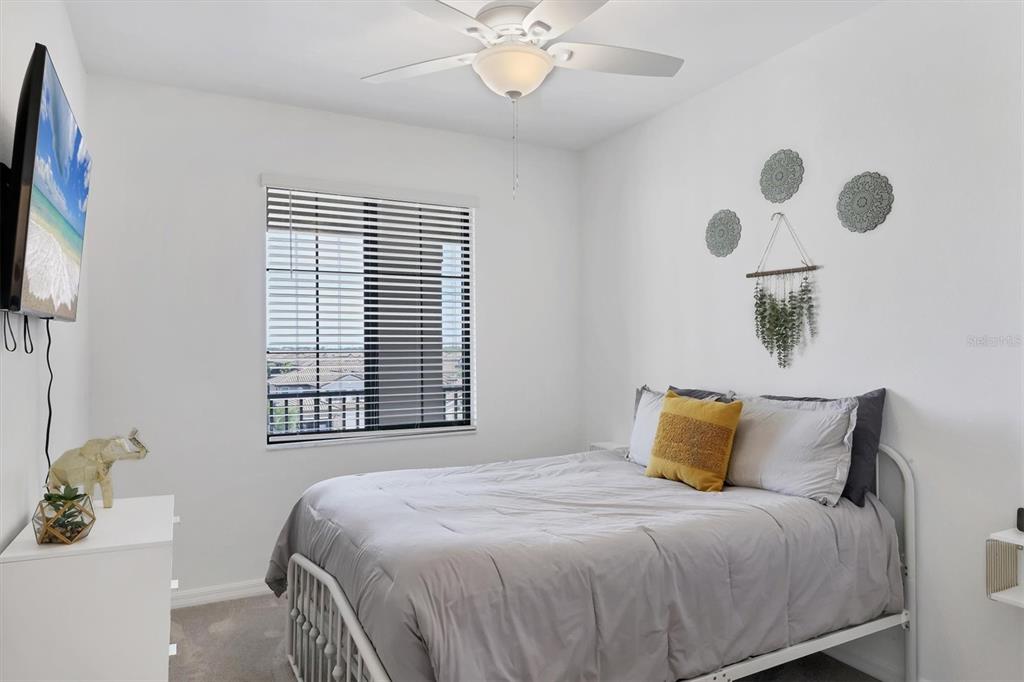 18114 Gawthrop Drive, Unit 405 Bradenton, FL 34211 - Photo 22 of 72 a bedroom with a bed and a chandelier