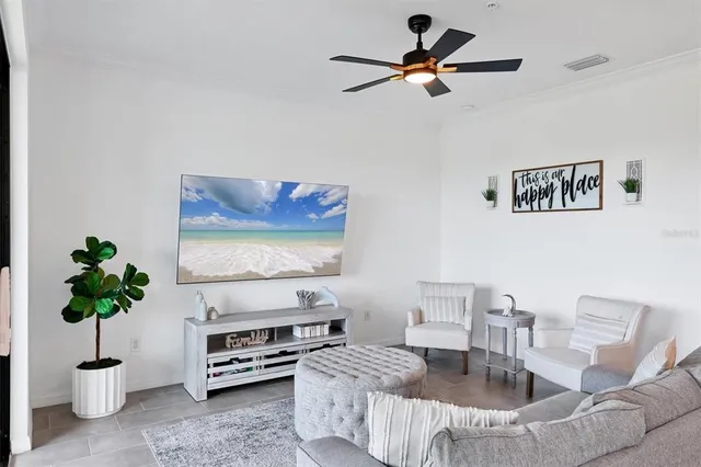 a kitchen with stainless steel appliances kitchen island granite countertop a sink a refrigerator a stove and white cabinets with wooden floor