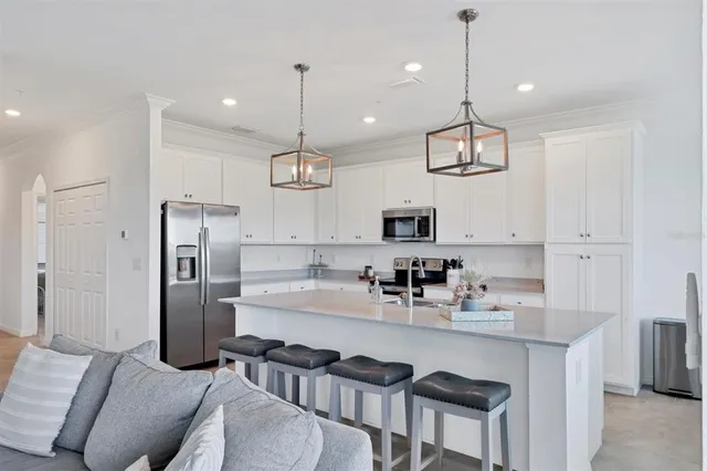 a kitchen with white cabinets sink and stainless steel appliances