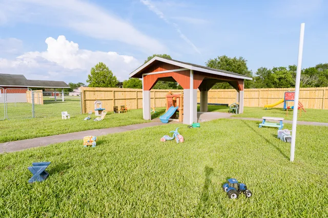 a view of a house with a yard and a table and chairs