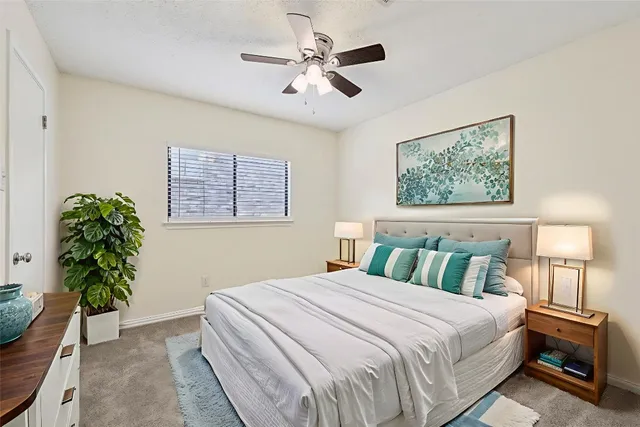 an empty room with a chandelier fan and windows