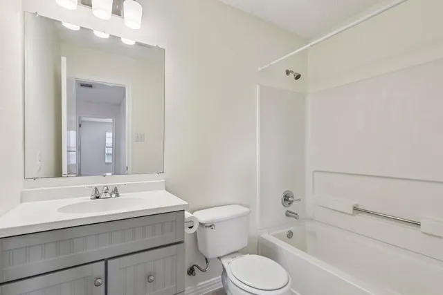 an empty room with windows and ceiling fan