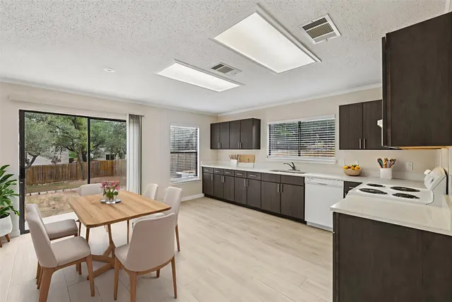 a kitchen with a table chairs microwave and cabinets