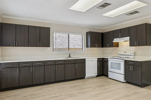 a kitchen with a sink cabinets and window