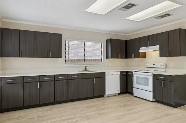 a kitchen with a sink cabinets and window
