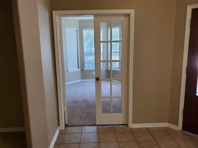an empty room with windows and fan