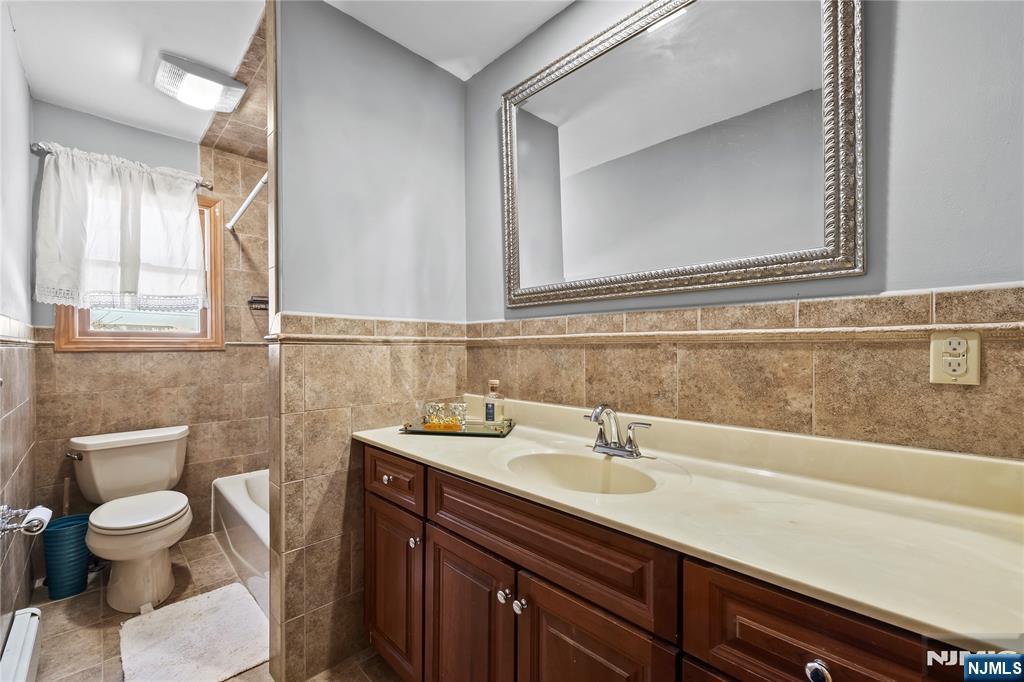 391 Taylor, Unit 2 Hackensack, NJ 07601 - Photo 8 of 15 a bathroom with a sink a toilet and a mirror