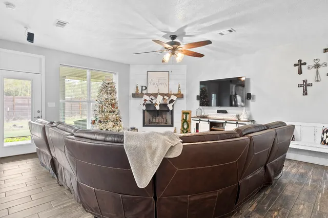 a living room with furniture a flat screen tv and a large window