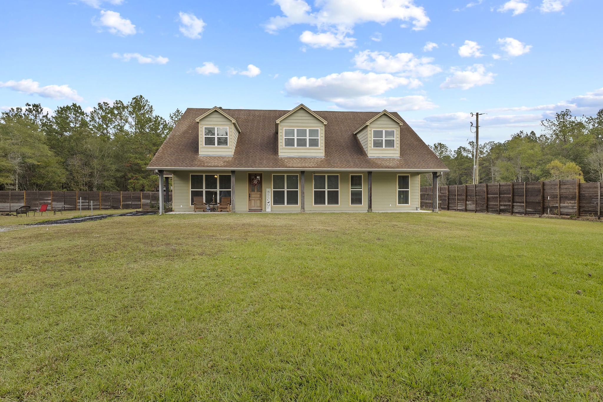 6938 Old Honey Island Road Kountze, TX 77625 - Photo 31 of 34 a view of a large building next to a yard with palm trees