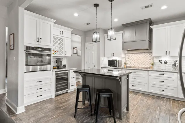 a kitchen with stainless steel appliances a stove a sink island and a refrigerator