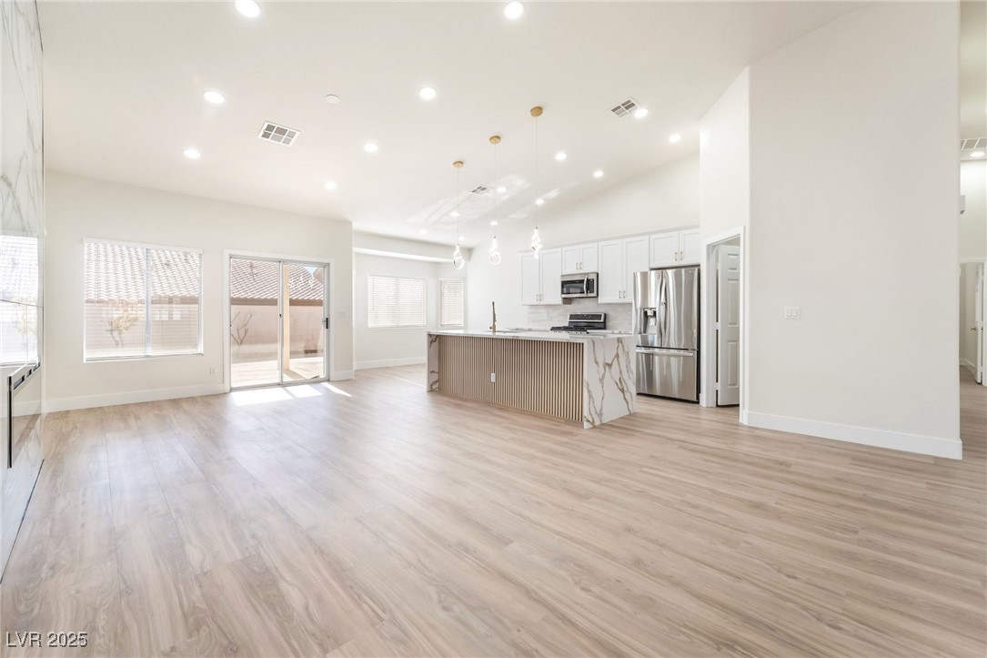 9205 Desert Village Avenue Las Vegas, NV 89147 - Photo 42 of 44 Kitchen with open floor plan, a kitchen island with sink, appliances with stainless steel finishes, recessed lighting, and white cabinetry