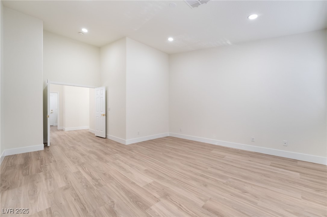 9205 Desert Village Avenue Las Vegas, NV 89147 - Photo 22 of 44 Empty room featuring light wood-style floors, recessed lighting, and a high ceiling