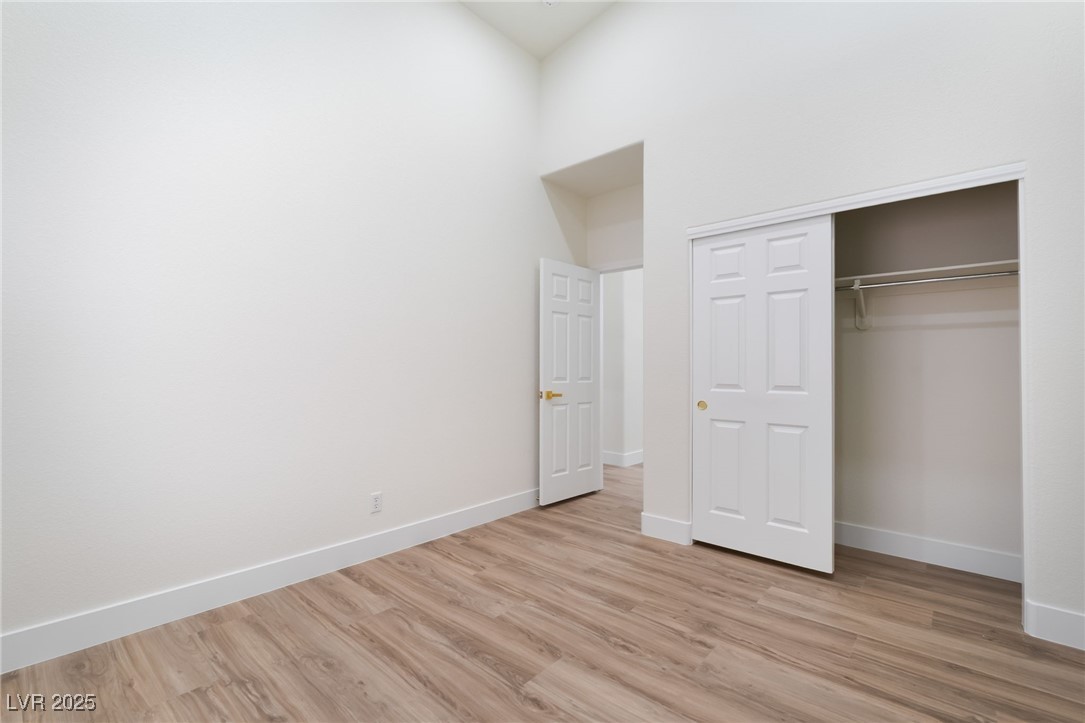 9205 Desert Village Avenue Las Vegas, NV 89147 - Photo 28 of 44 Unfurnished bedroom with light wood-style floors, a closet, and a high ceiling