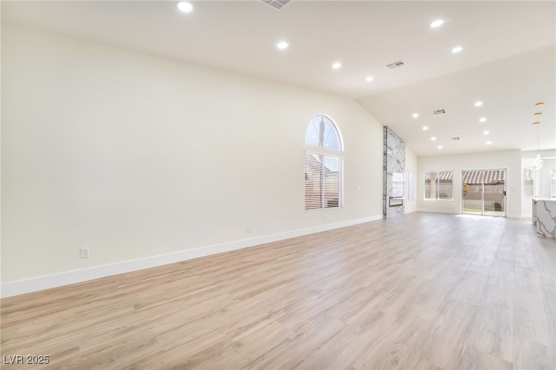 9205 Desert Village Avenue Las Vegas, NV 89147 - Photo 8 of 44 Unfurnished living room with recessed lighting, light wood finished floors, and lofted ceiling