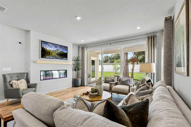 a living room with furniture a large window and a flat screen tv